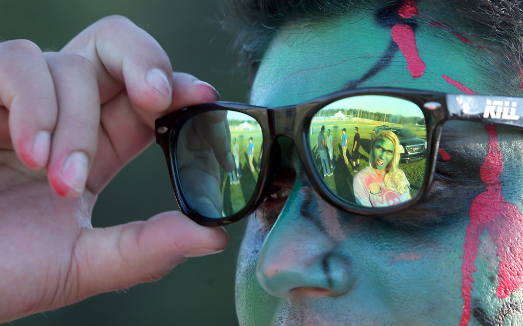Misty Gutshall is reflected in Christopher Gil's sunglasses at the third annual Running Scared Zombie 5k Run at Harder's Park in Panama City. (Panama City Photographer/Andrew Wardlow)
