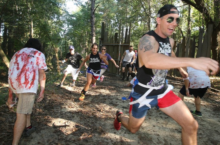 Runners attempt to avoid the zombies during the third annual Running Scared Zombie 5k Run at Harder's Park in Panama City. (Panama City Photograper/Andrew Wardlow)