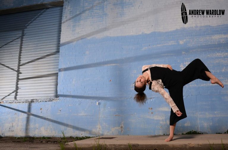 Dancer does a pose against blue wall during a Panama City dance photographer session.