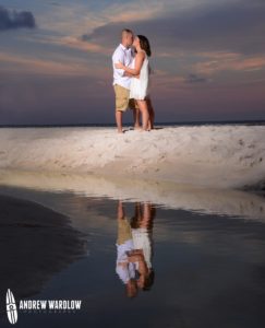 A couple poses at sunset in Panama City Beach after getting engaged.