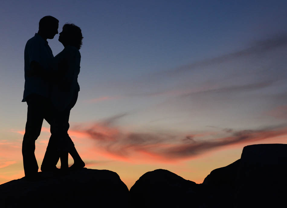 Happy couple photographed at sunset at St. Andrews State Park in Panama City Beach, Florida.