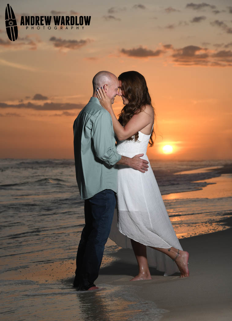 A couple embraces at sunset in Panama City Beach, Florida.