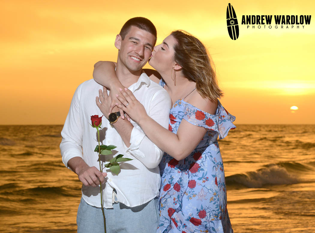 A woman kisses her fiance after he proposed at Sunset in Panama City Beach, Florida.