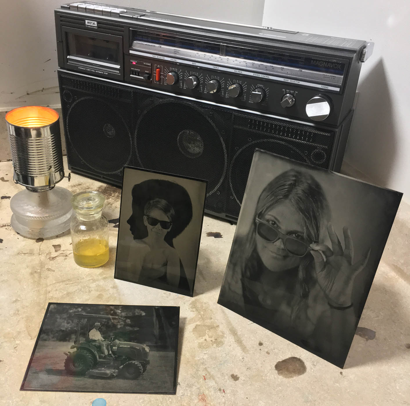 Tintypes sit around a radio in a darkroom.