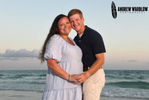 A couple smiles as they are photographed at sunset in Panama City Beach, Florida.