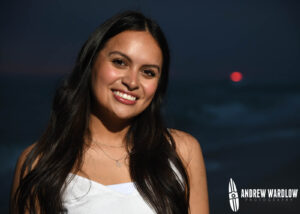 A young woman smiles for the camera as the sun goes down in Panama City Beach, Florida.