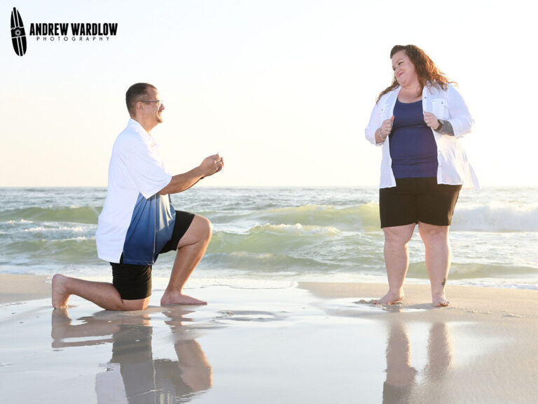 A man proposes as waves crash in the background in Panama City Beach, Florida.