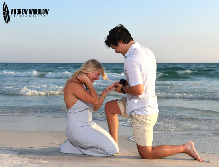 A man slides a ring on his fiancé's finger 
after proposing in Panama City Beach, Florida.